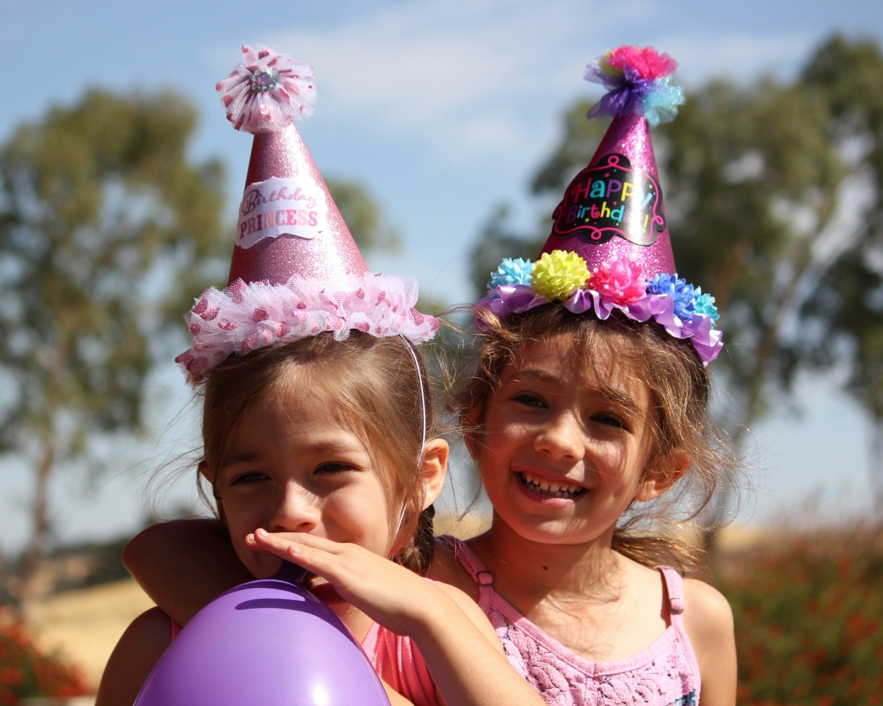 Две маленькие веселые девочки отмечают день рождения