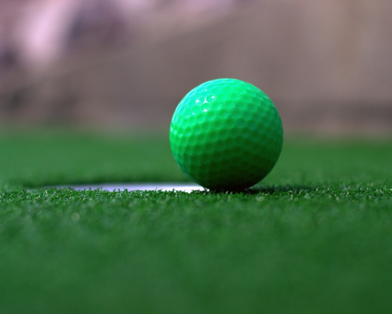 Зеленый мяч для игры в гольф на траве