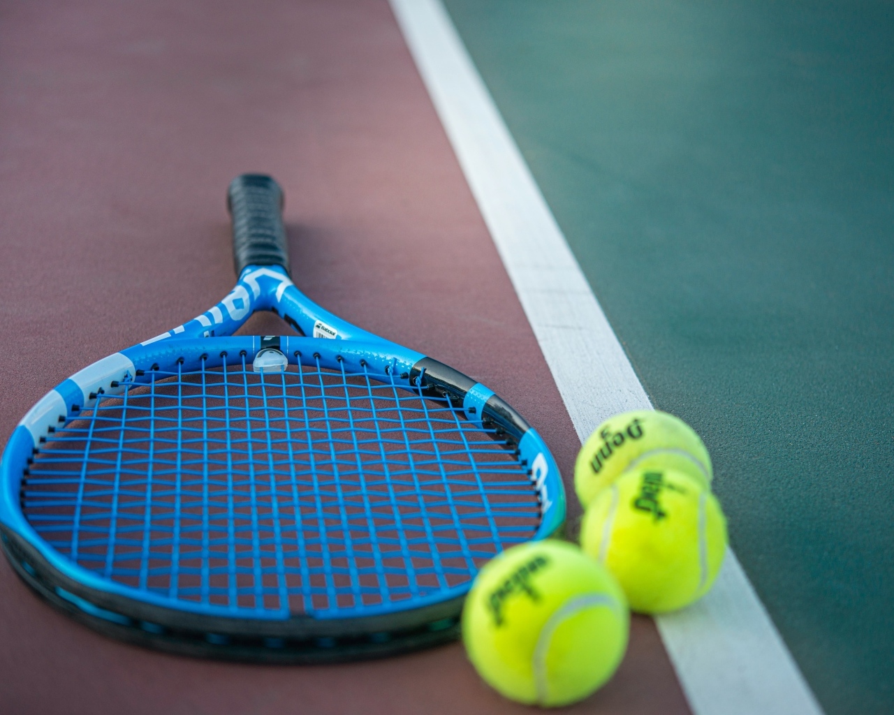 Ракетка и теннисные  мячи на корте