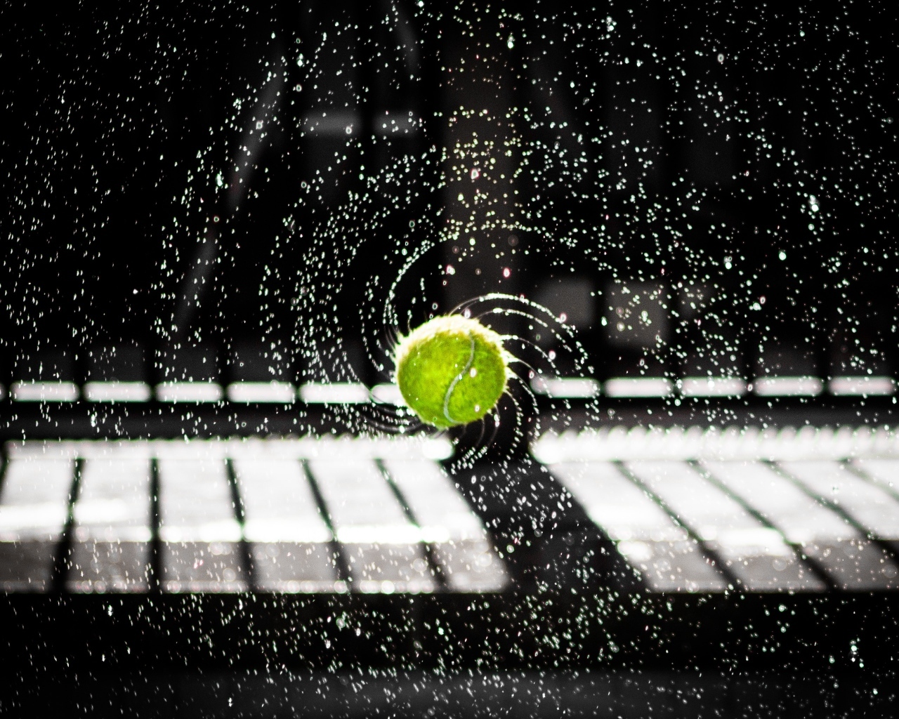Теннисный мяч в брызгах воды