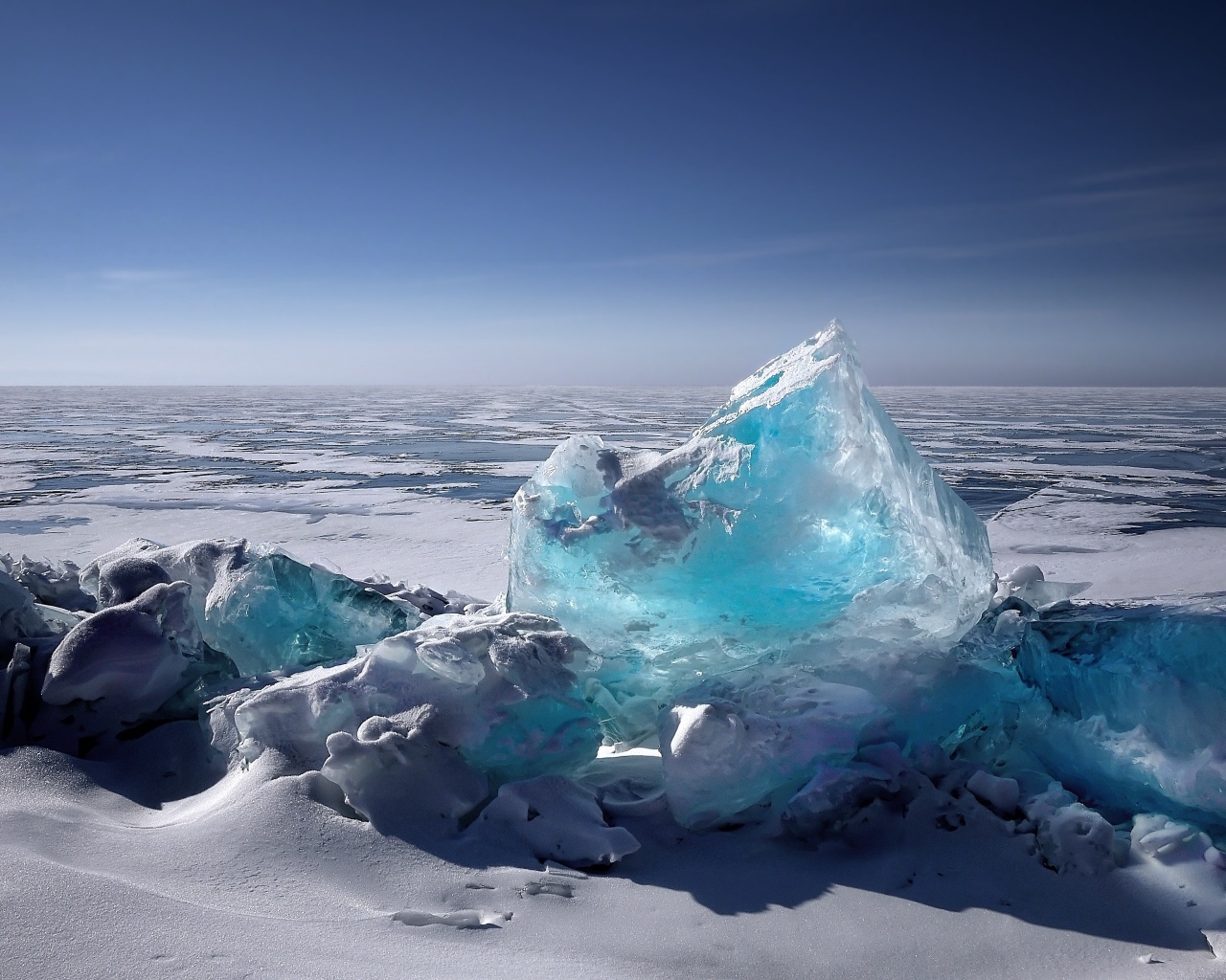 Большая голубая льдина на берегу океана