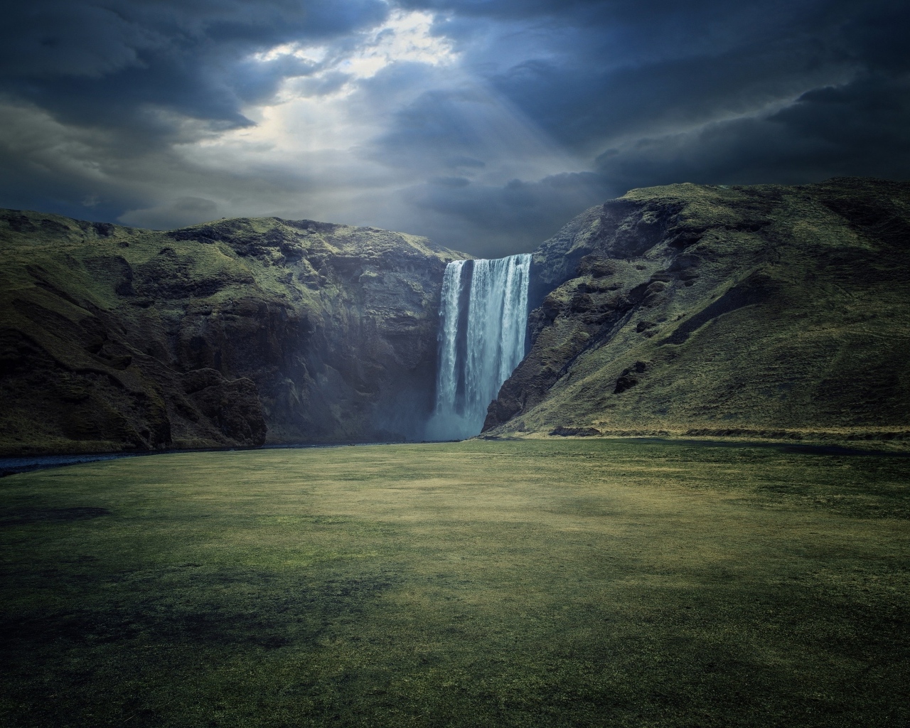Лунный свет падает на горный водопад Скогафосс, Исландия
