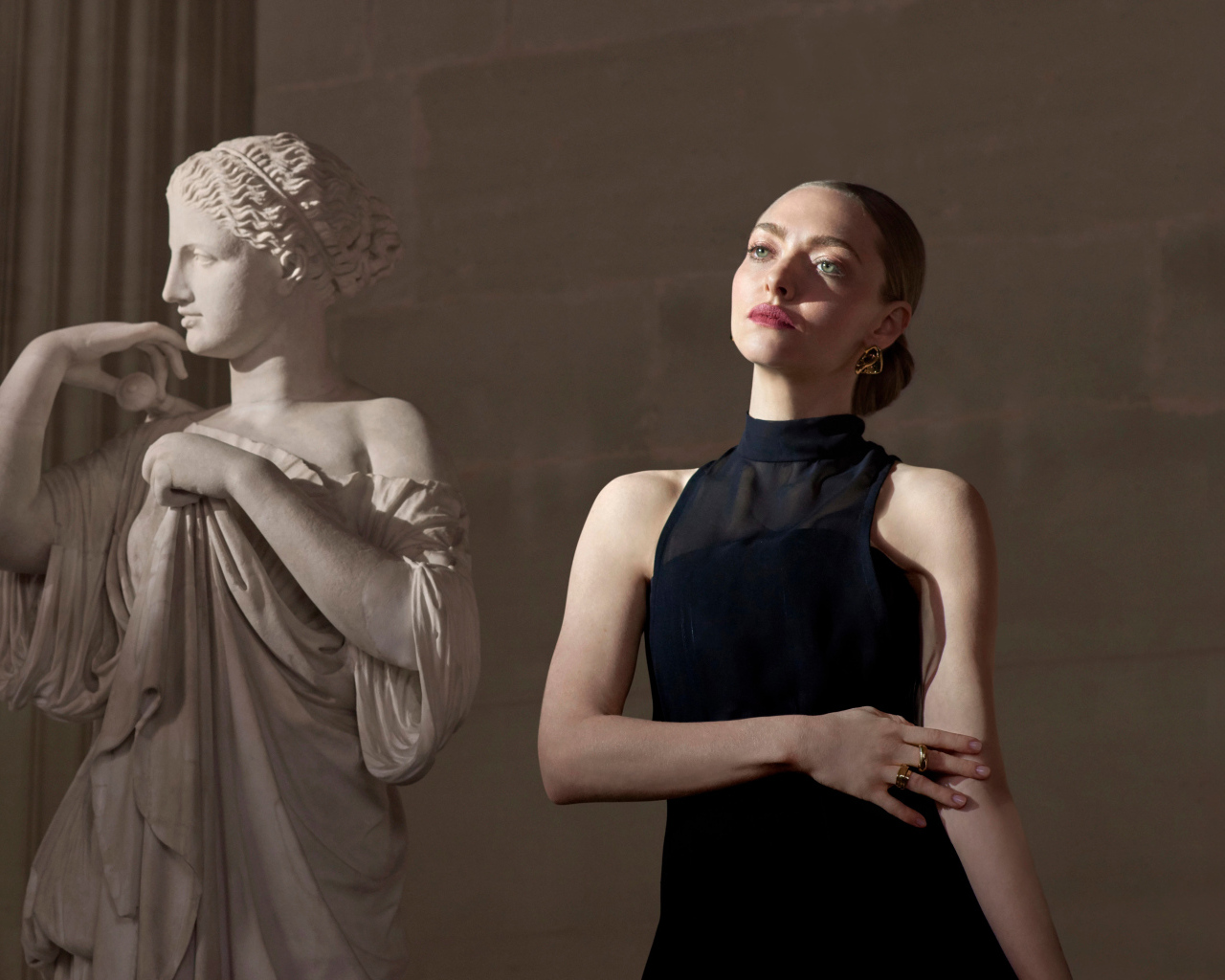 Актриса Аманда Сайфред в черном платье у статуи