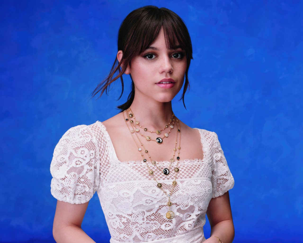 Актриса Дженна Ортега в белом платье на голубом фоне