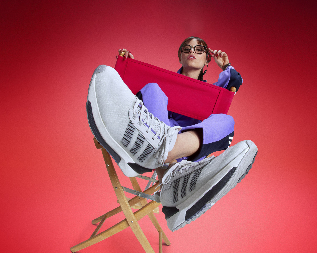 Актриса Дженна Ортега в кроссовках адидас сидит на стуле