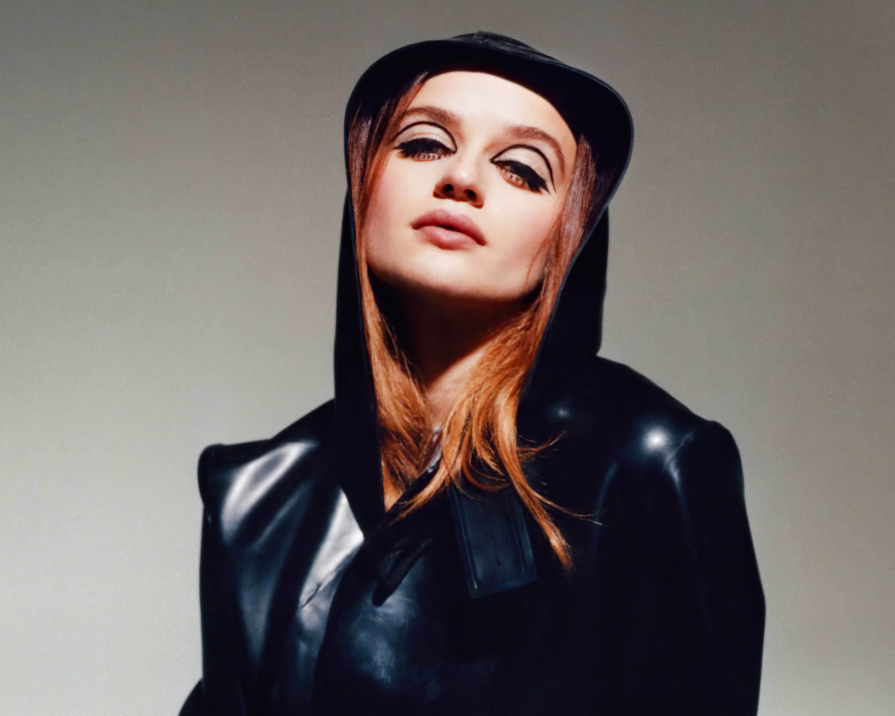 Актриса Джоуи Кинг в черной куртке на сером фоне