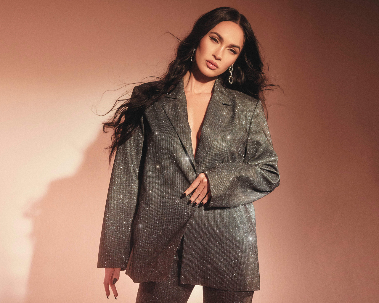 Актриса Меган Фокс в ярком костюме у стены