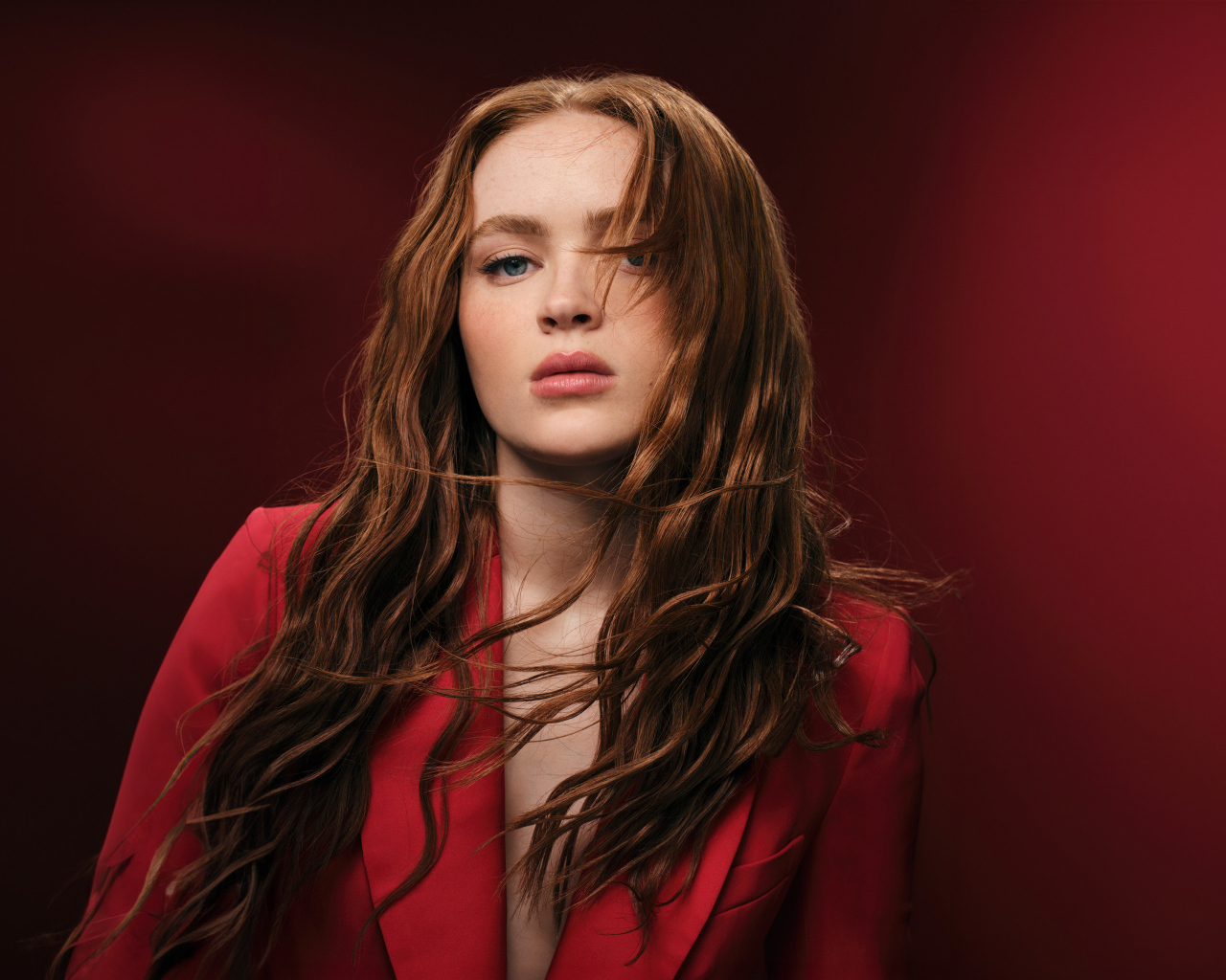 Американская актриса Сэди Синк на красном фоне