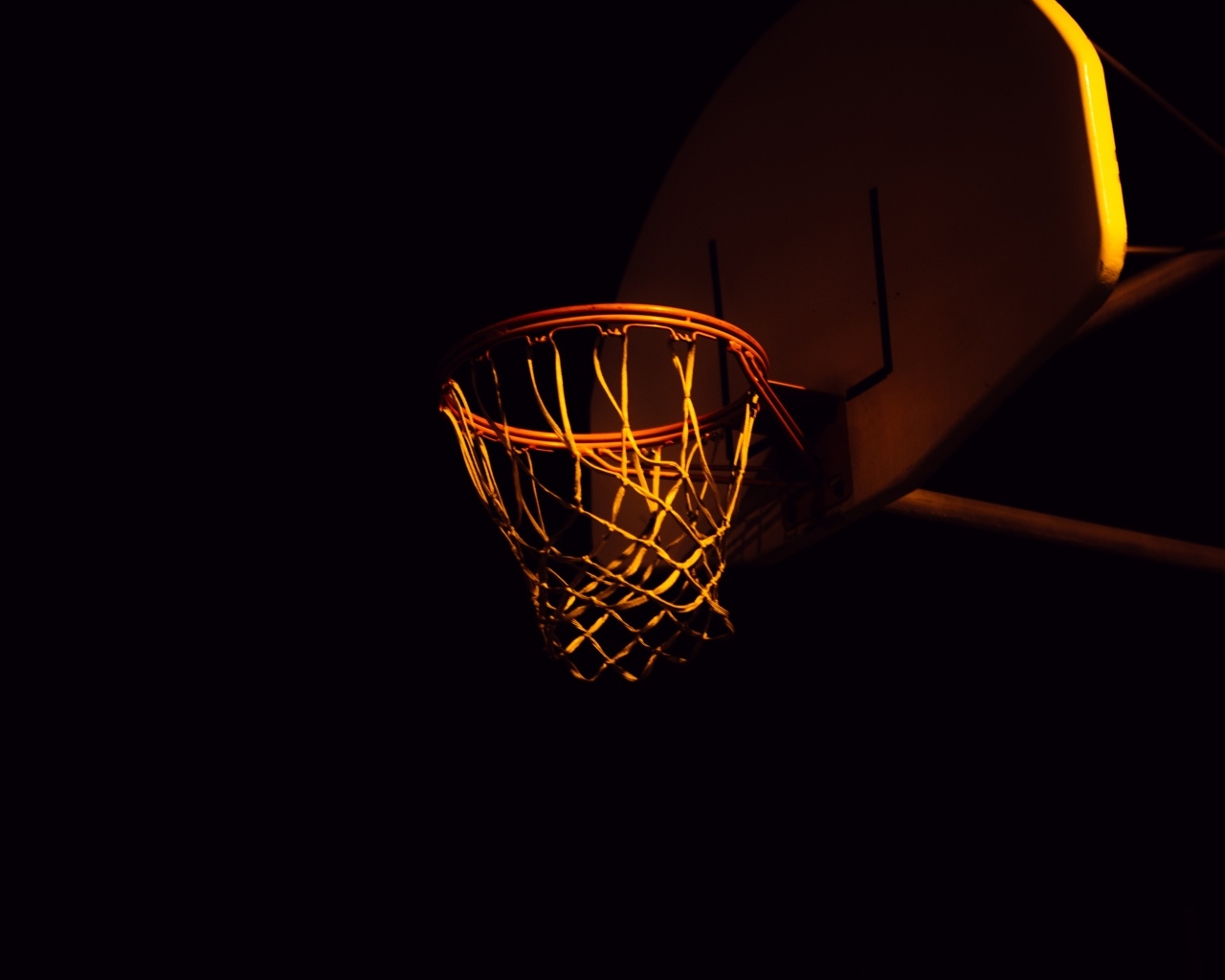 Баскетбольное кольцо в лучах света ночью