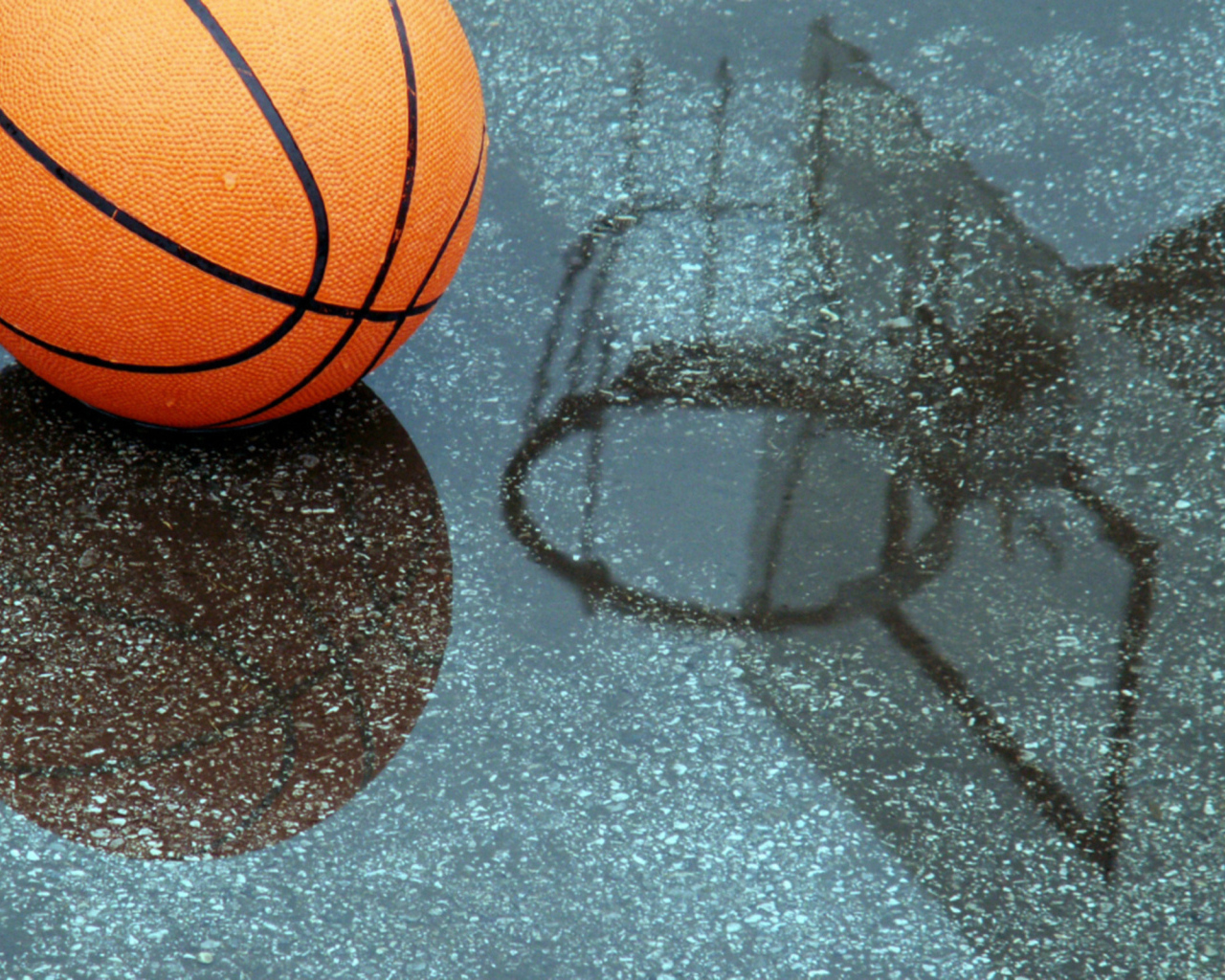 Баскетбольный мяч отражается в мокрой поверхности