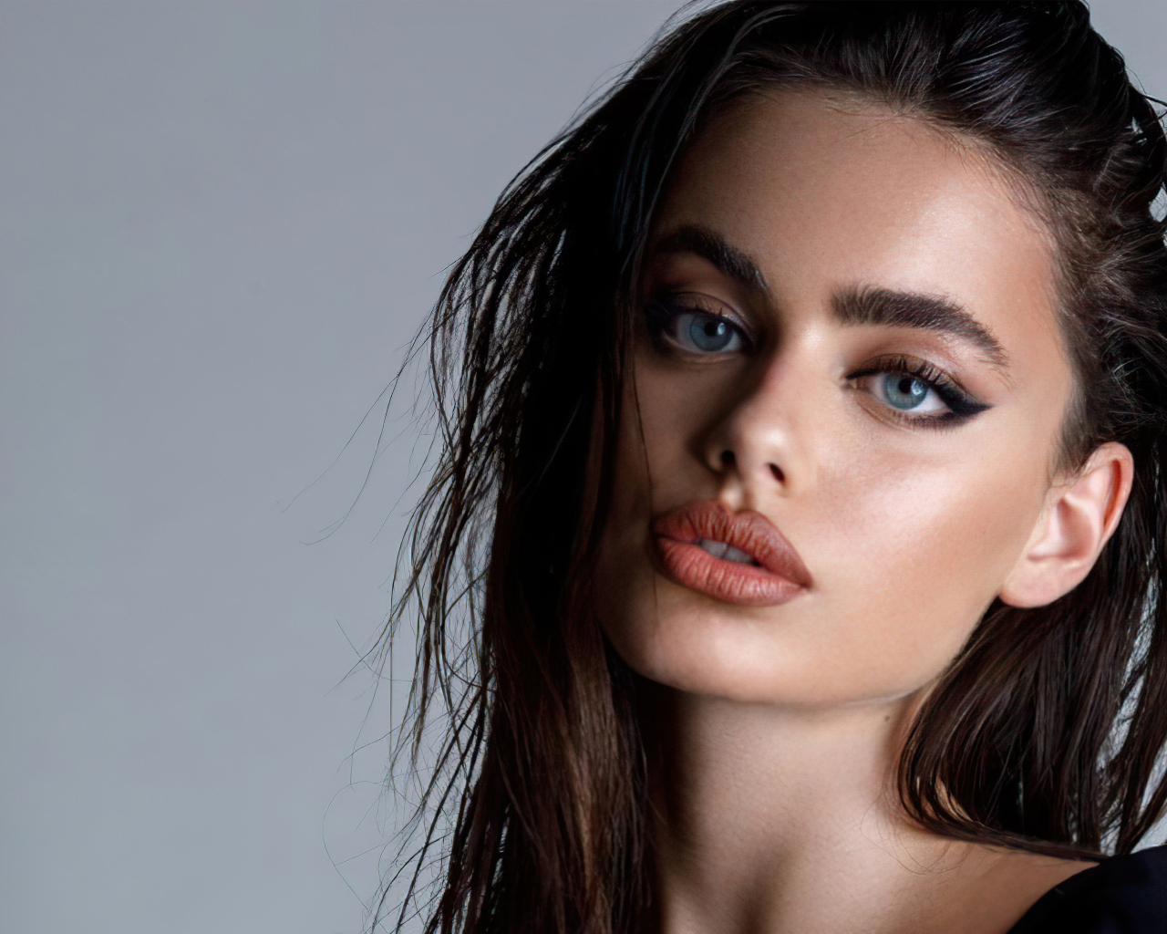 Красивая голубоглазая девушка Яэль Шелбиа на сером фоне