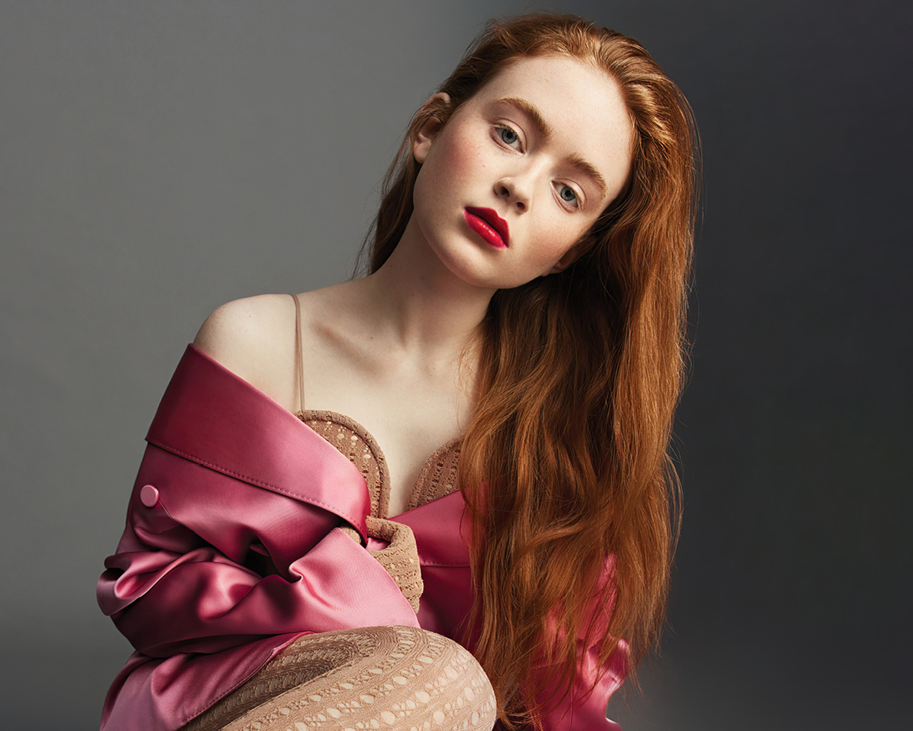 Красивая рыжеволосая девушка Сэди Синк на сером фоне