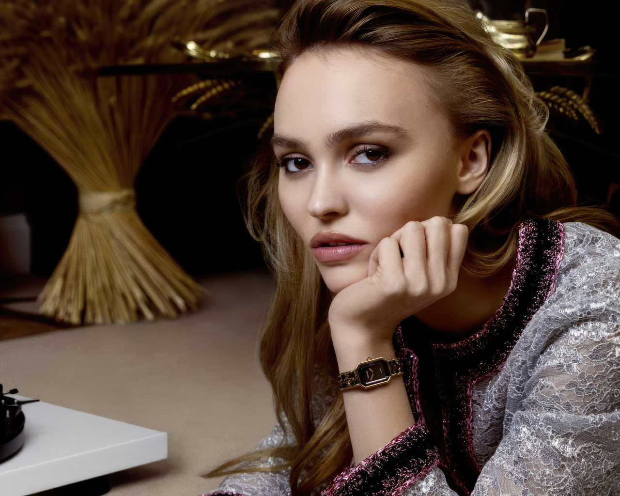 Милая девушка Лили-Роуз Депп сидит за столом