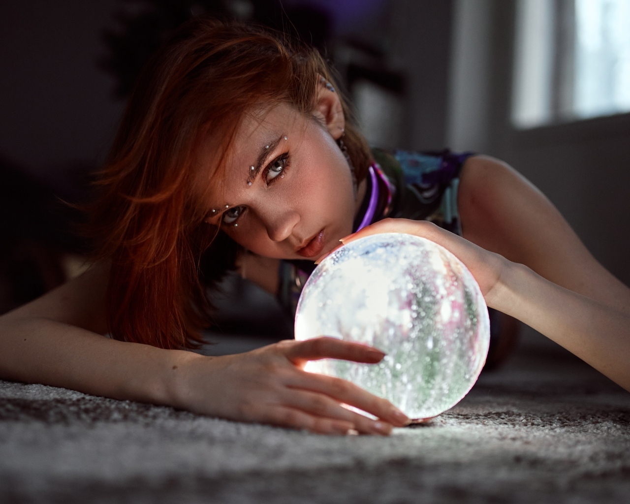 Девушка с пирсингом держит волшебный шар