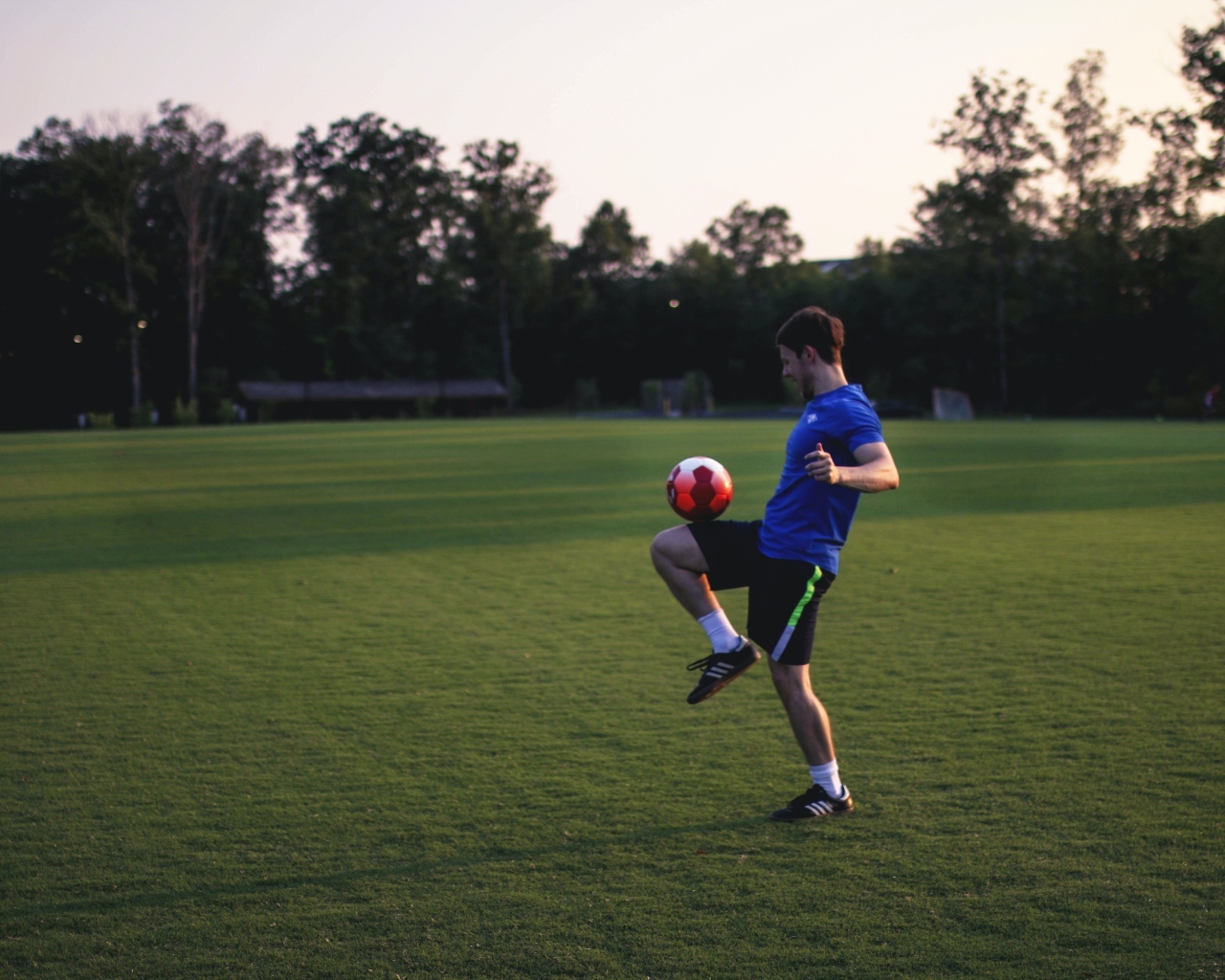 Мужчина футболист с мячом на поле