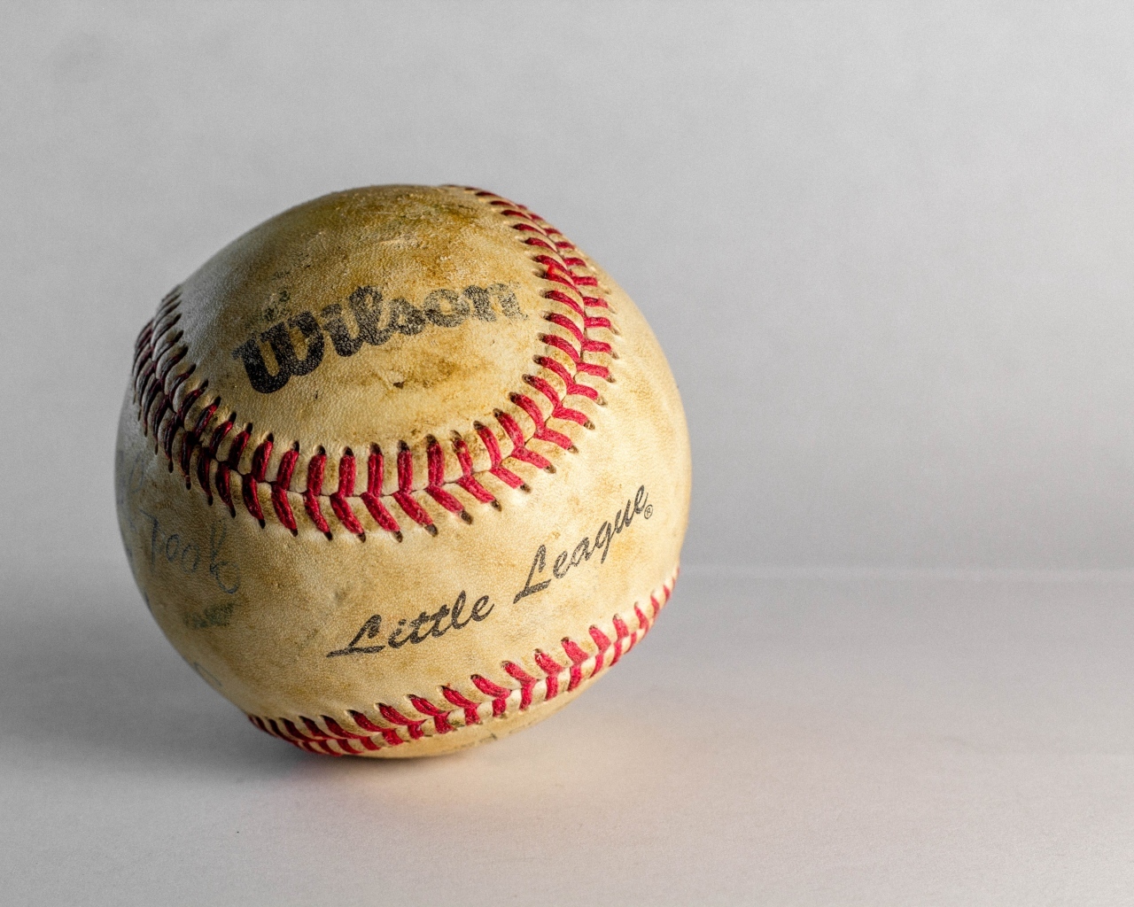 Старый бейсбольный мяч на сером фоне