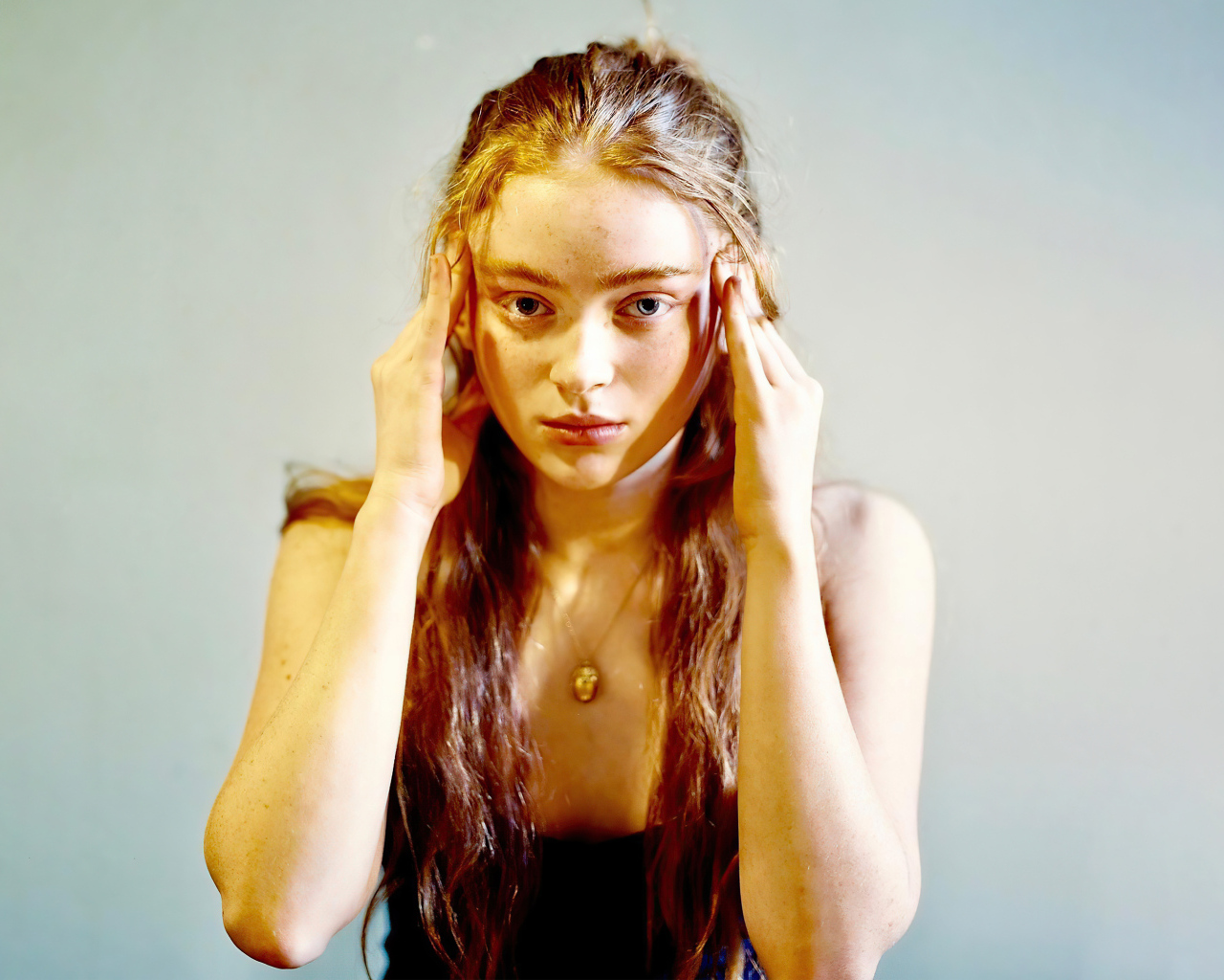 Рыжеволосая американская актриса Сэди Синк на сером фоне