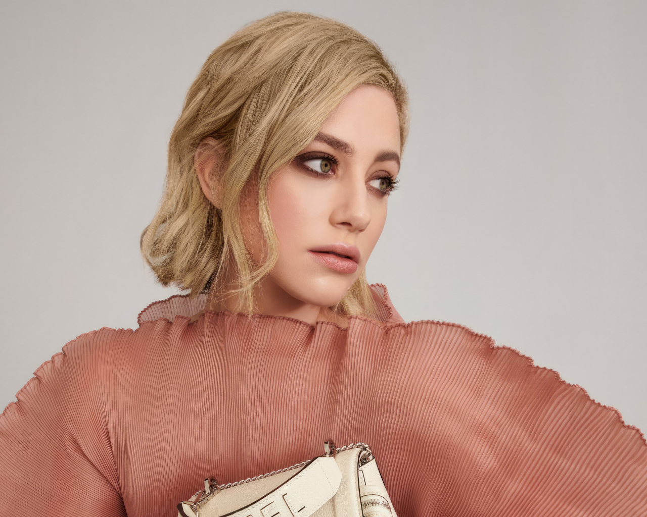 Грустный взгляд актрисы Лили Рейнхарт на сером фоне