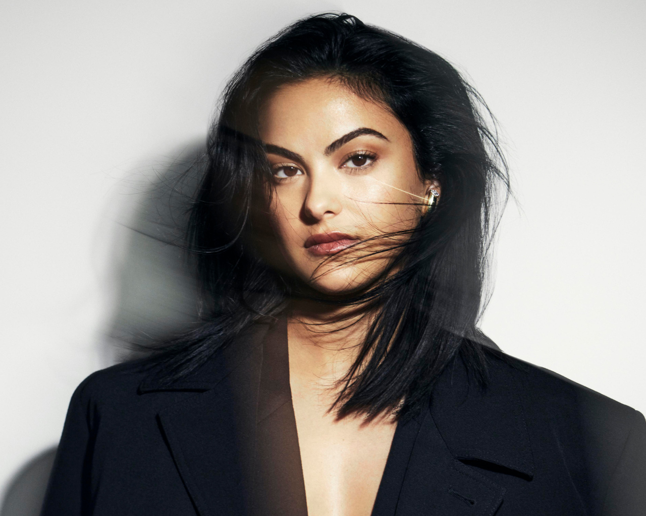 Стильная актриса Камила Мендес в черном пиджаке на сером фоне