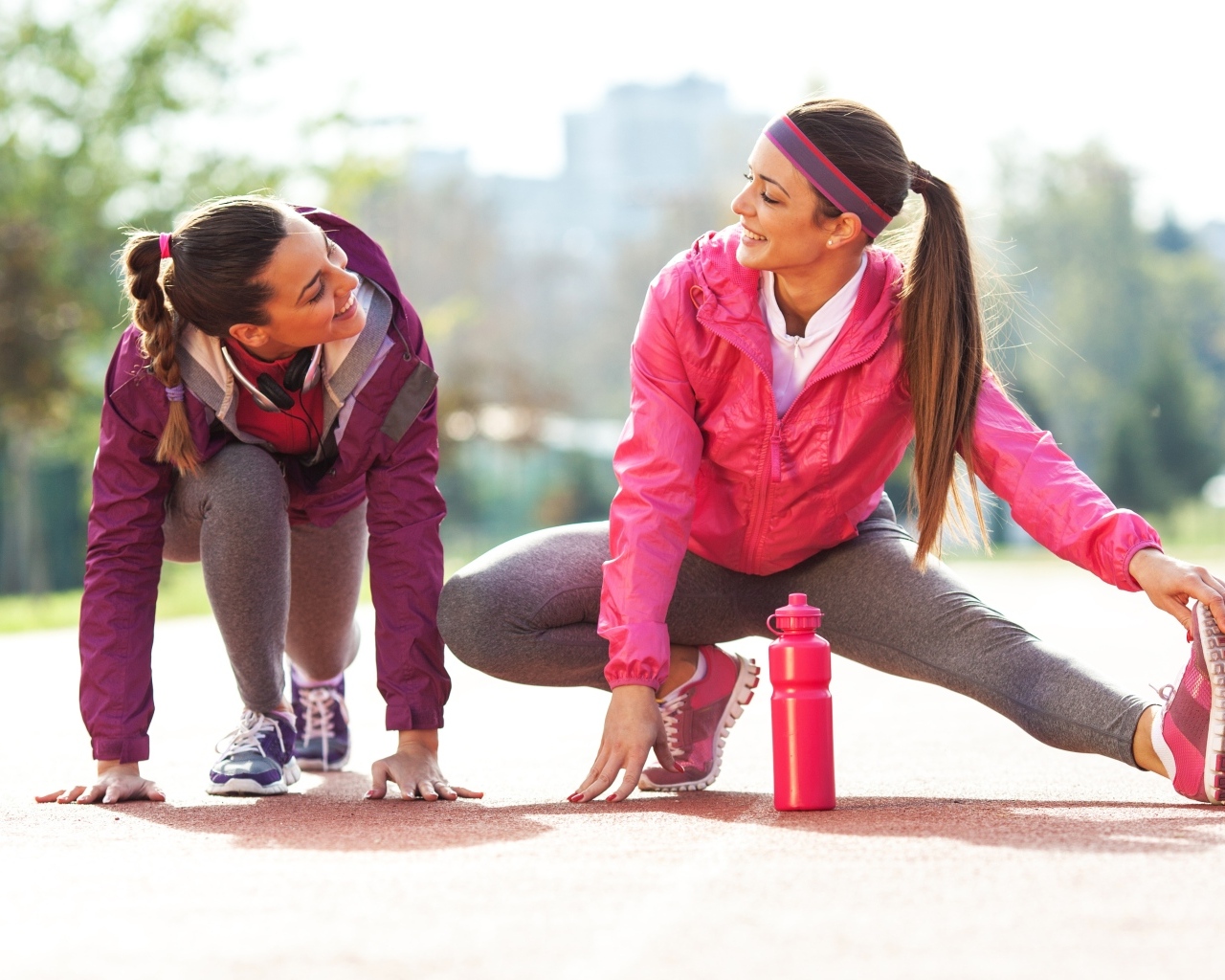Две спортивные девушки делают растяжку 