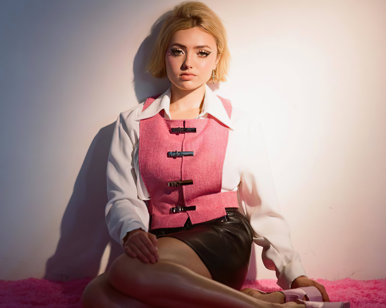 Молодая девушка Пейтон Рой Лист сидит у стены