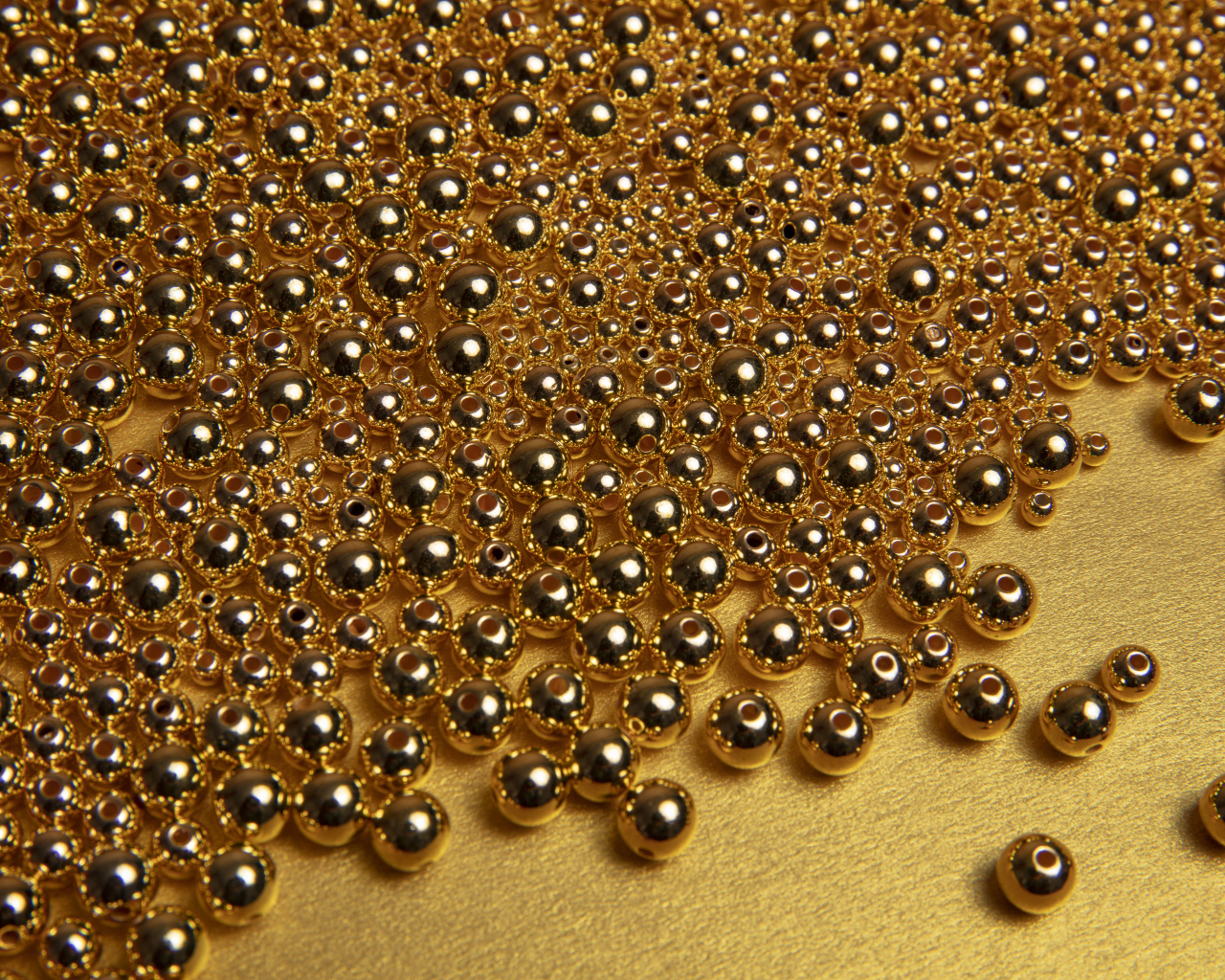 Много золотых бусин на желтом фоне