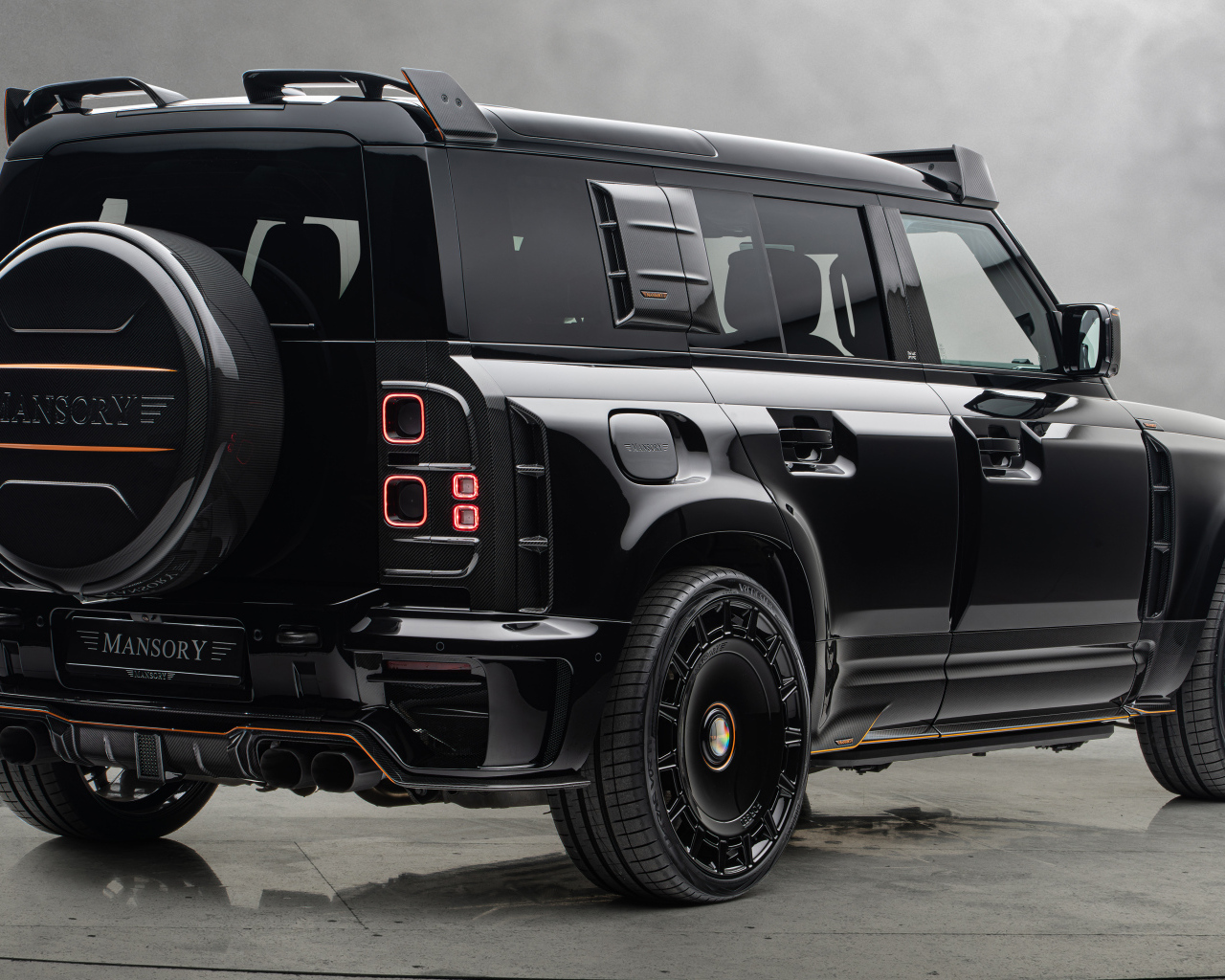 Вид сзади на черный автомобиль Mansory Land Rover Defender 110 Black Edition 2024 года