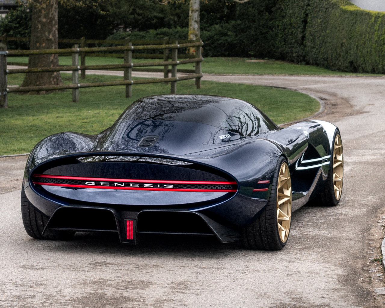 Вид сзади на черный дорогой автомобиль Genesis X Gran Berlinetta Tribute 2024  года