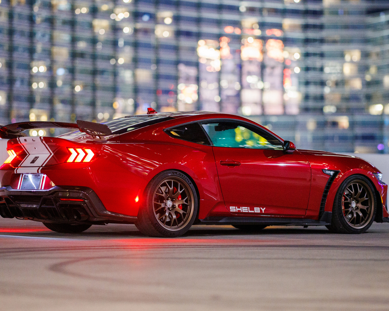 Вид сзади на красный автомобиль  Shelby Super Snake 2024 года