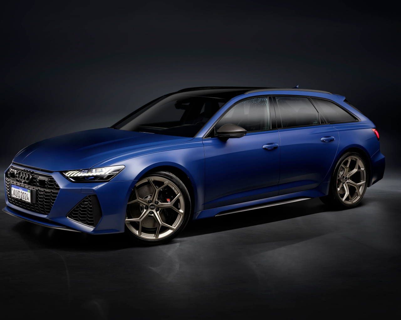 Синий автомобиль Audi RS 6 Avant Legacy 2024 года на сером фоне