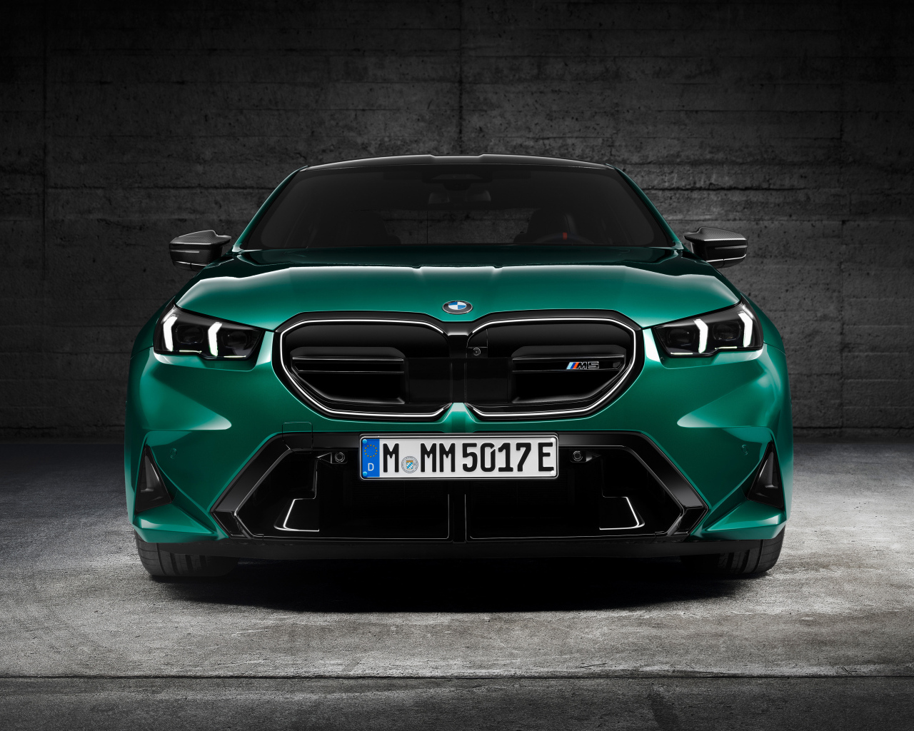 Зеленый автомобиль BMW M5 2024  года вид спереди