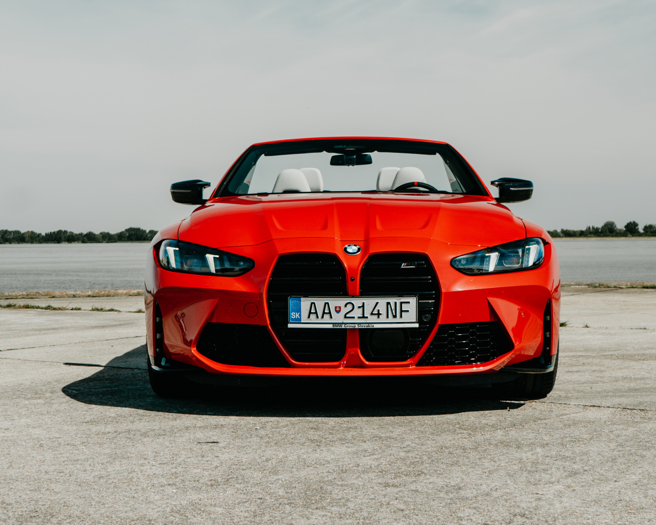 Вид спереди на красный автомобиль BMW M4 Competition M xDrive Cabrio 2024 года