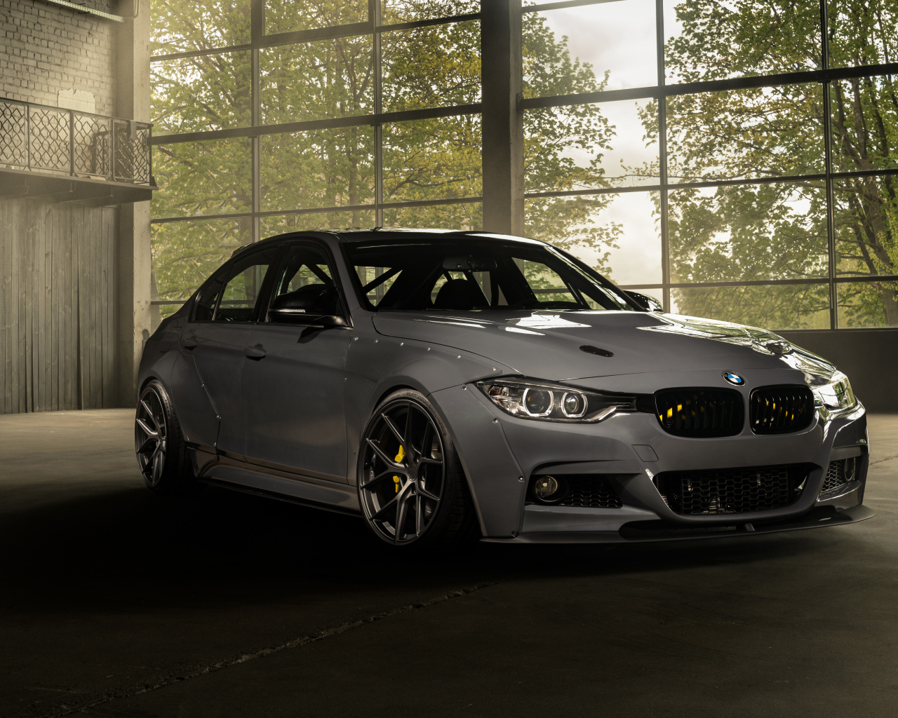 Белый автомобиль BMW F30 Widebody в здании