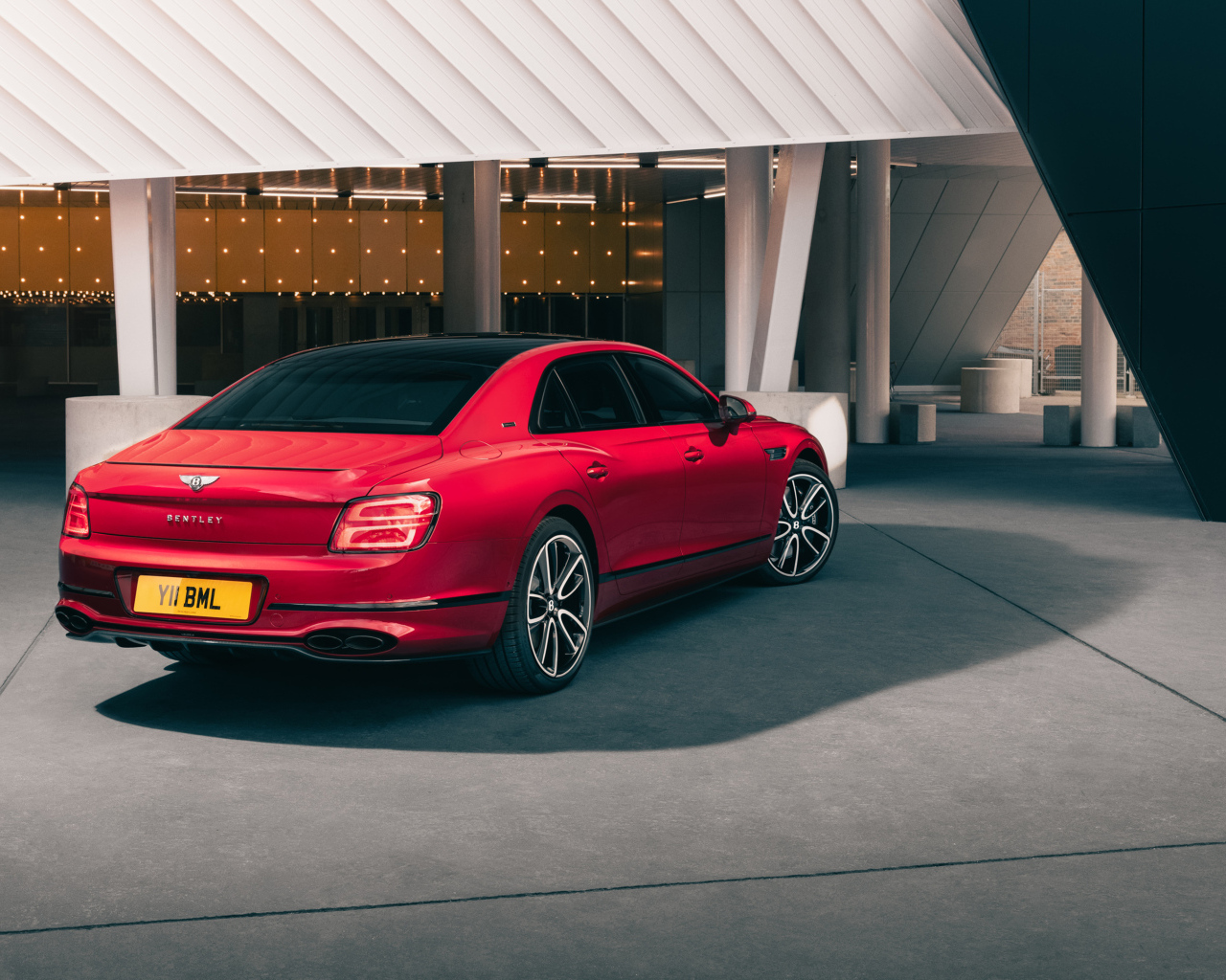 Вид сзади на красный автомобиль Bentley Flying Spur V8 Edition 2024 года