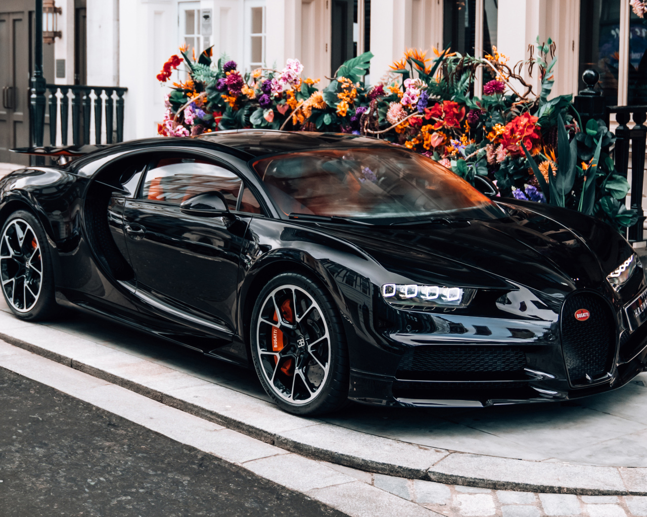 Черный автомобиль Bugatti Chiron у здания