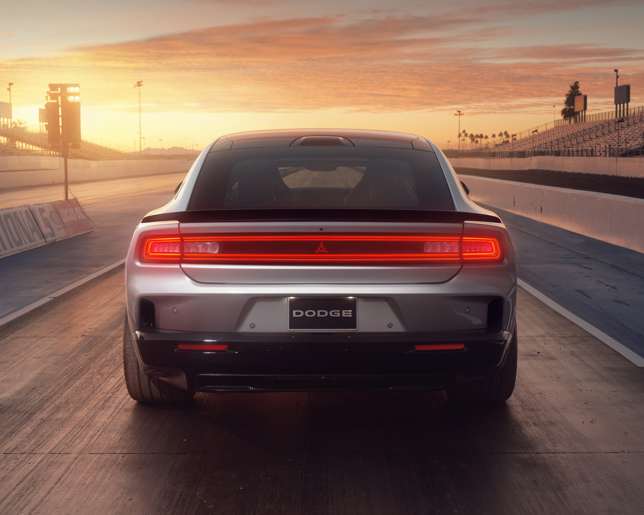 Вид сзади на автомобиль Dodge Charger Daytona Scat Pack 2024 года на закате