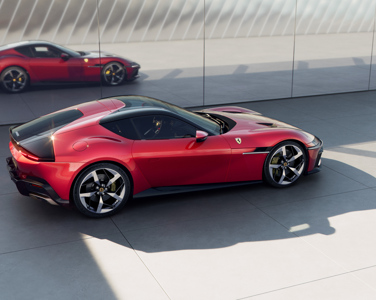 Красный автомобиль Ferrari 12Cilindri 2024 года у стены