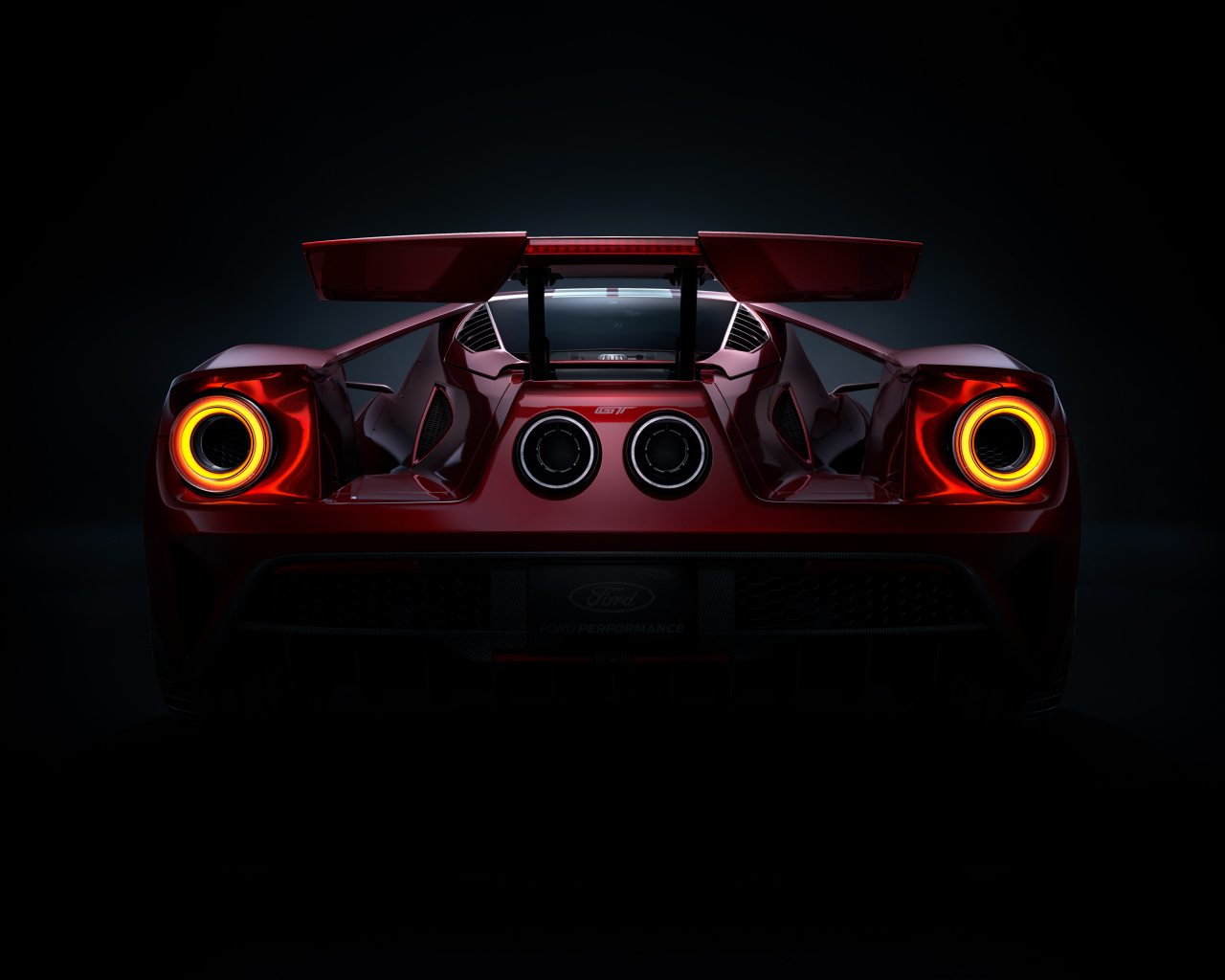 Вид сзади на автомобиль Ford GT  на черном фоне