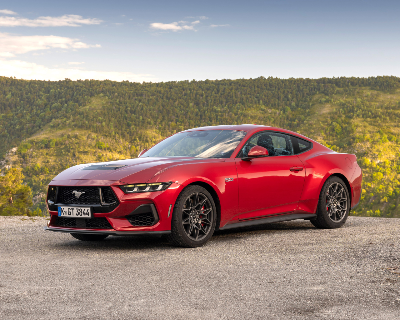 Красный автомобиль Ford Mustang GT 2024 года