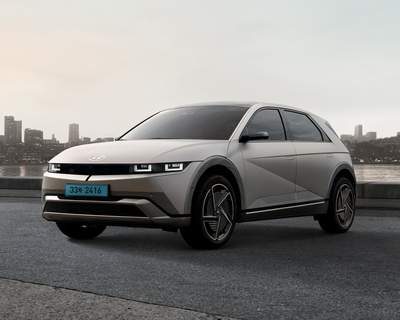 Серебристый автомобиль   Hyundai IONIQ 5 2024 года на фоне города