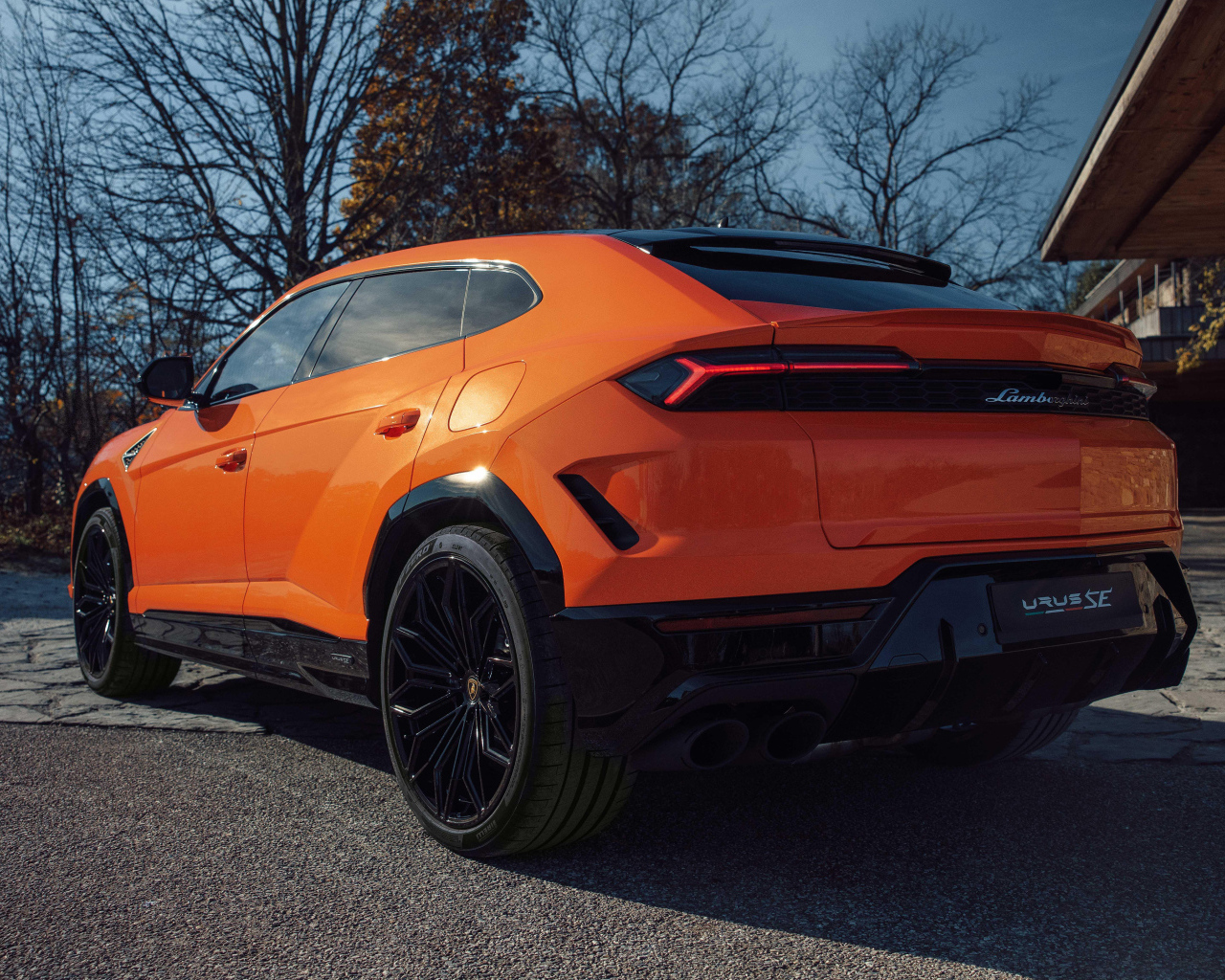 Вид сзади на оранжевый внедорожник Lamborghini Urus SE Plug-In Hybrid