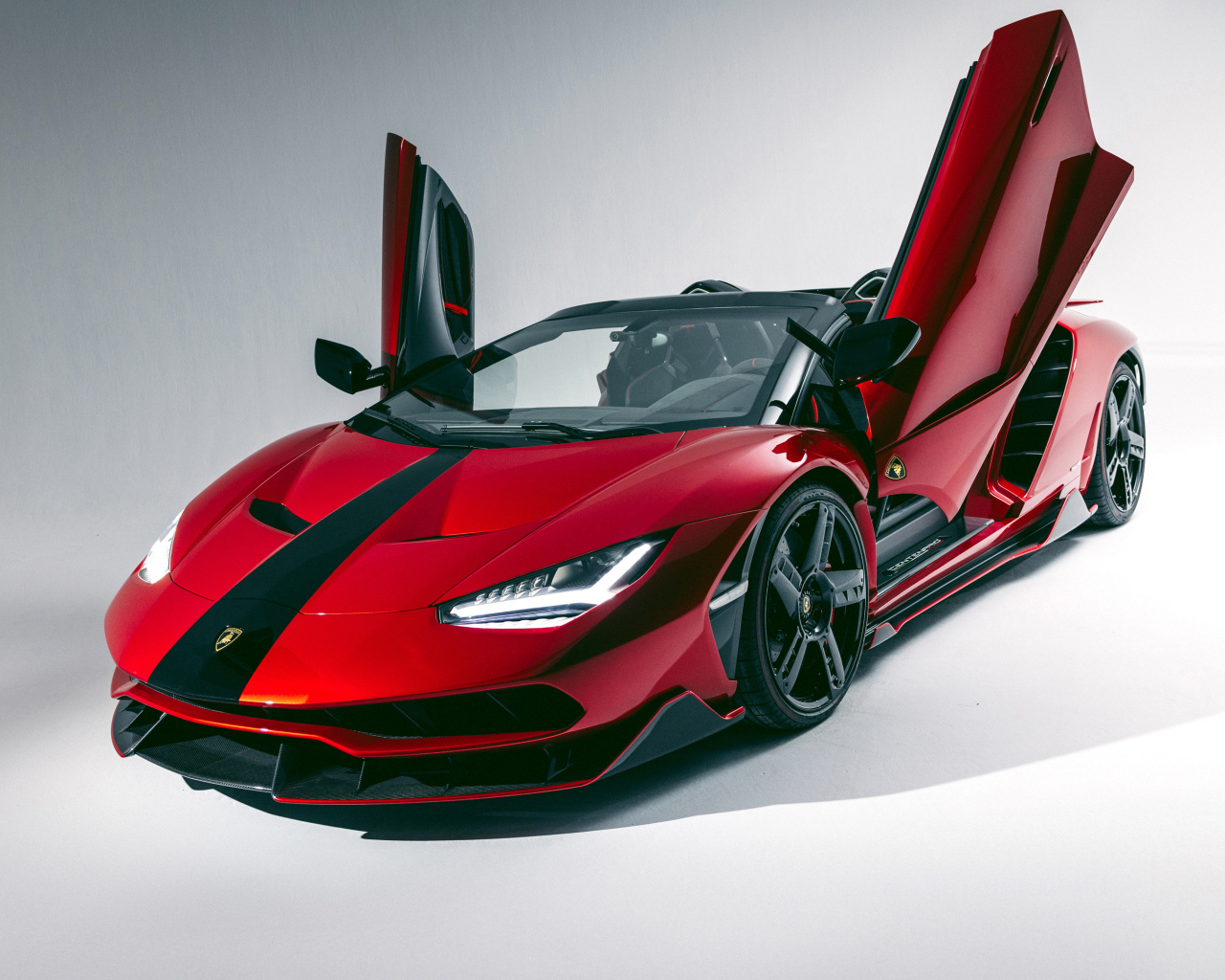 Красный автомобиль Lamborghini Centenario Roadster с открытыми дверями