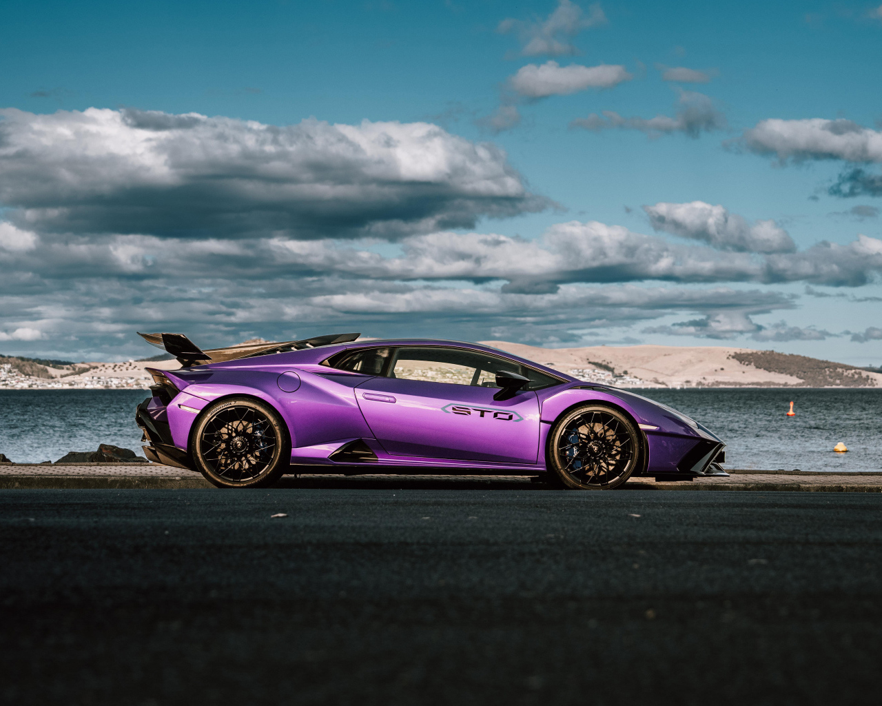 Вид сбоку на автомобиль Lamborghini Huracan STO на фоне неба