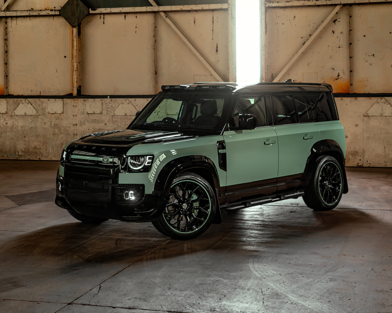 Вид спереди на автомобиль Land Rover Defender Widetrack 2024 года