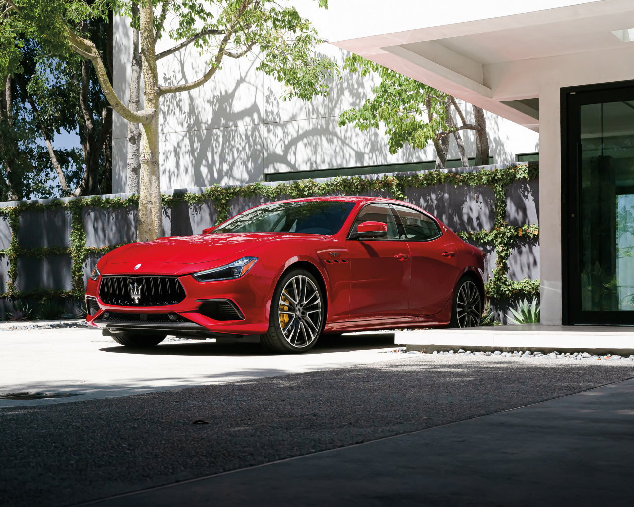 Красный автомобиль Maserati Ghibli Trofeo у дома