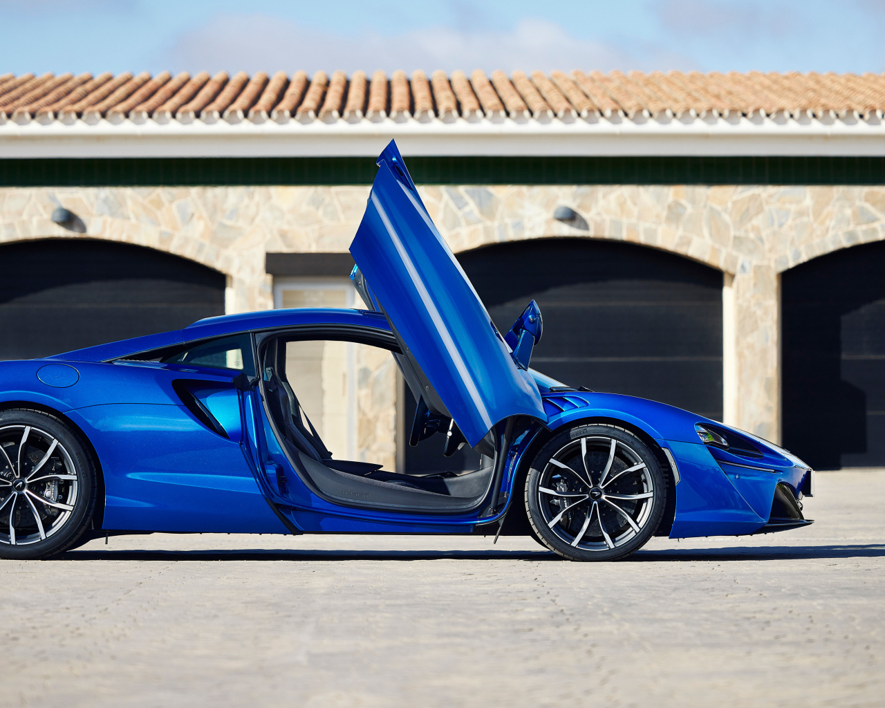 Синий автомобиль McLaren Artura с открытыми дверями