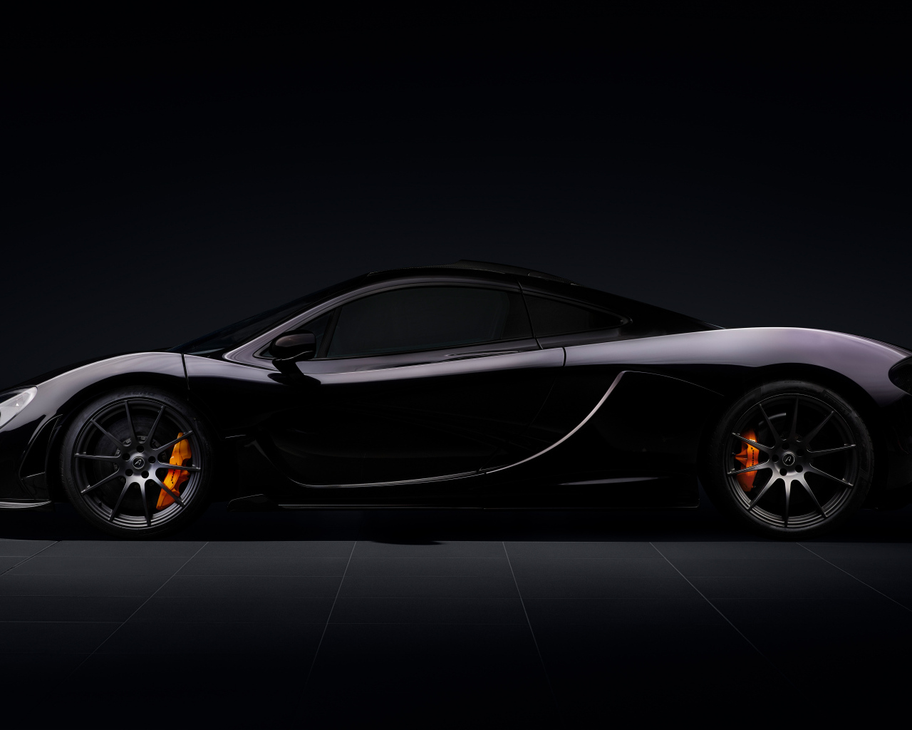 Вид сбоку на автомобиль McLaren P1 на черном фоне
