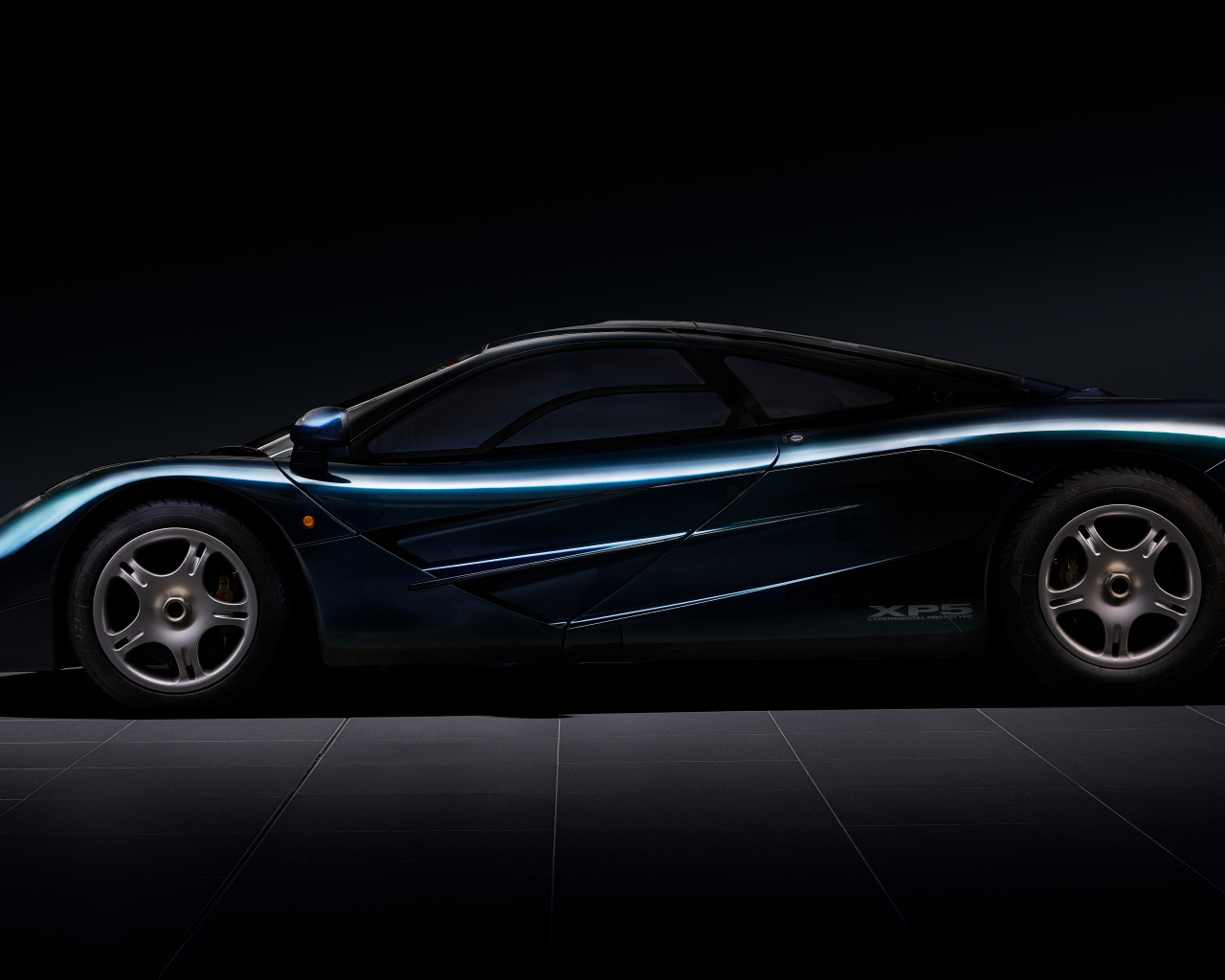 Вид сбоку на черный дорогой автомобиль McLaren F1