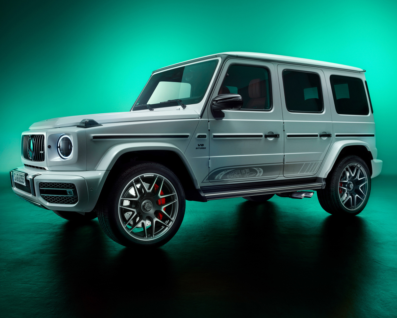 Автомобиль Mercedes-AMG G63 на зеленом фоне