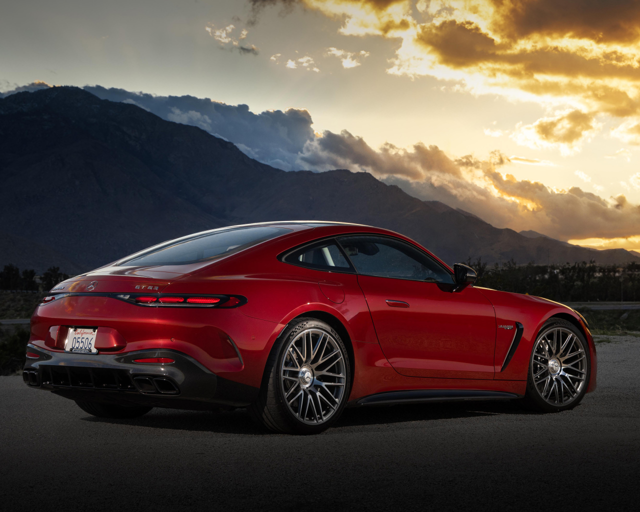 Вид сзади на красный автомобиль Mercedes-AMG GT 63 4MATIC+ 2024 года на закате